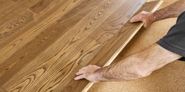 Person installing wooden flooring.