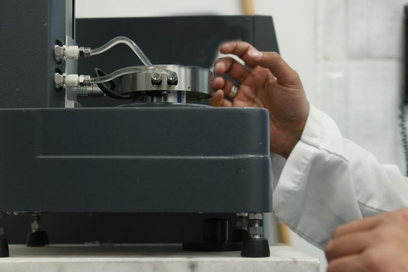 Scientist in a laboratory testing using an analytical testing device measuring viscosity.