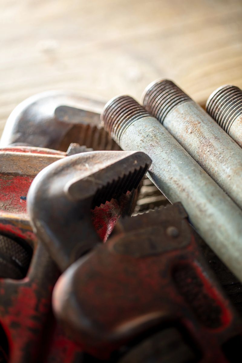Plumber's tools with pipe,  wrench on wood surface in a row