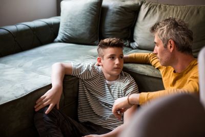 Father and son having a serious conversation on the floor.