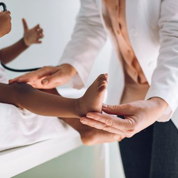 Doctor examining a child's foot during a medical checkup.