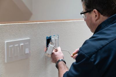 Electrician installing a switch on a wall.