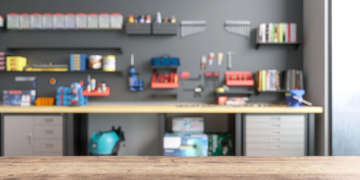 Clean wooden workbench with organized tools and shelves in a workshop.