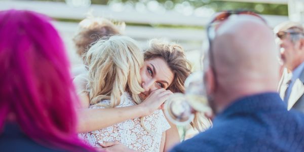 Two women hugging, one emotional.