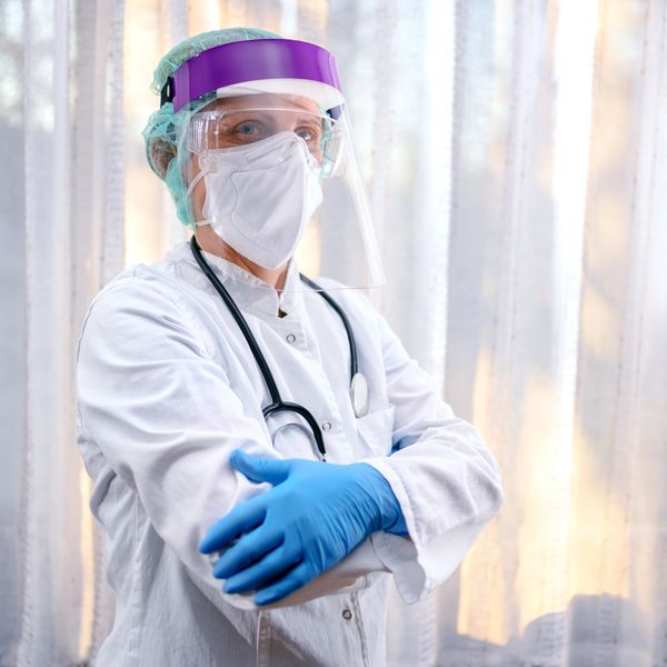 Healthcare worker wearing full protective gear and gloves.