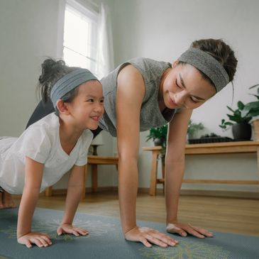 Mother and daughter doing push-ups together.