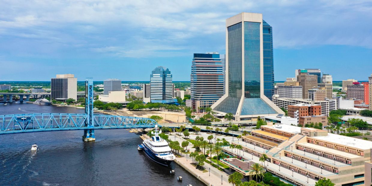 City skyline with river and blue bridge on a clear day.
