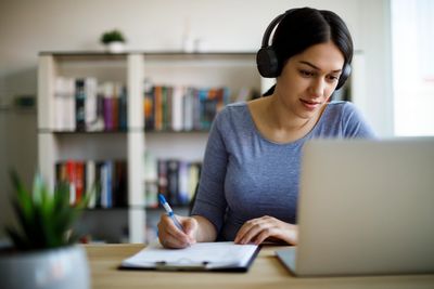 Young woman studying with headphones on.
