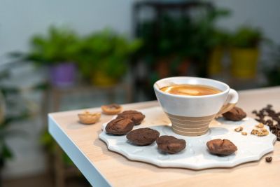 Coffee cup with chocolate treats on a white plate.