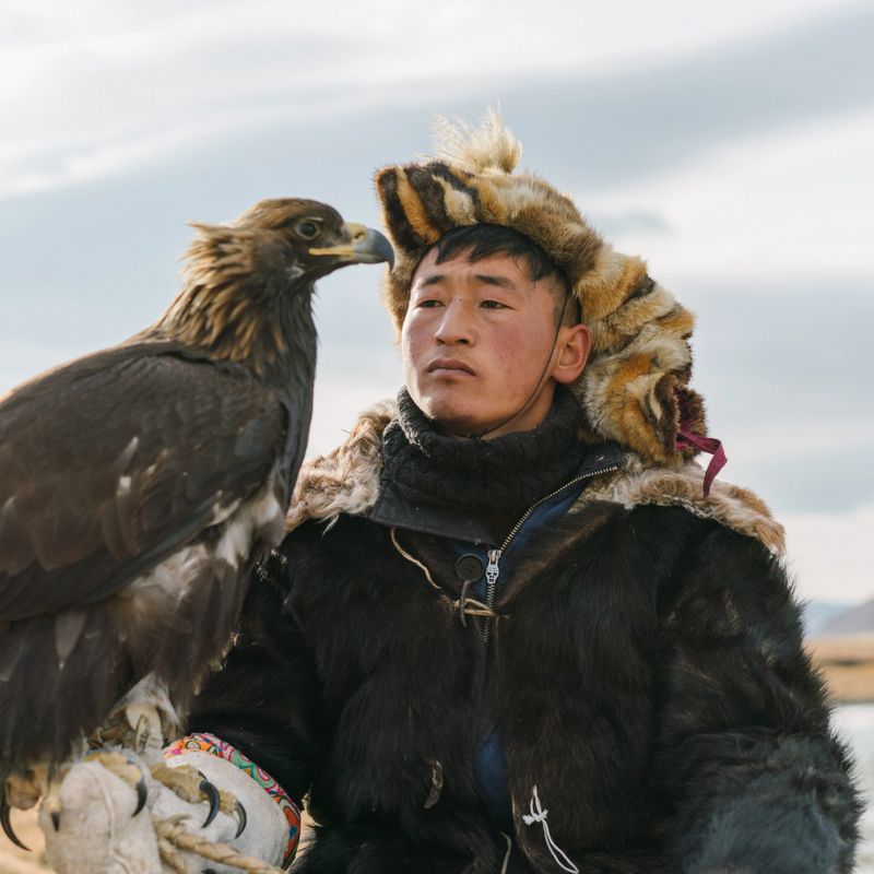 Portrait of eagle hunter  near the river  in Mongolia