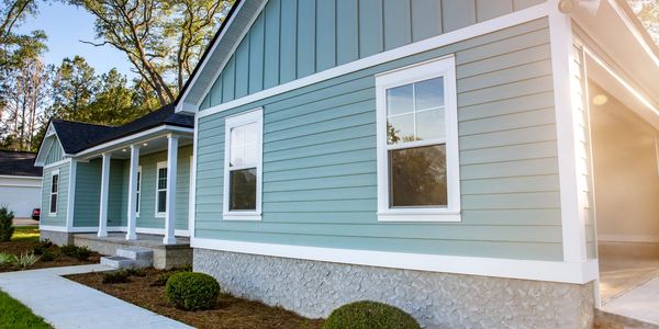 Blue house exterior with white trim and a small porch in daylight.