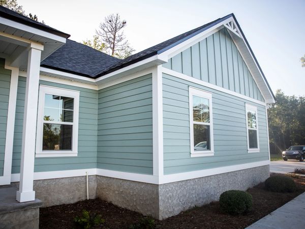 Modern house exterior with light blue siding and white trim.