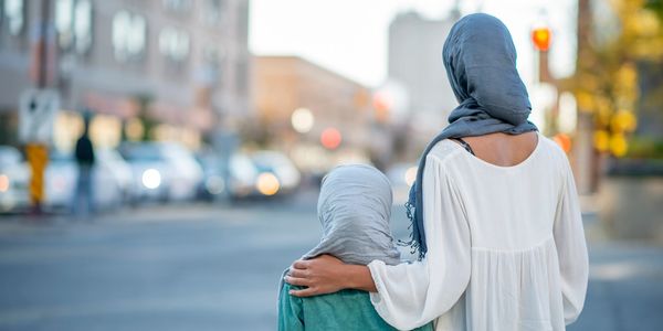Two girls with headscarves walking in the city.