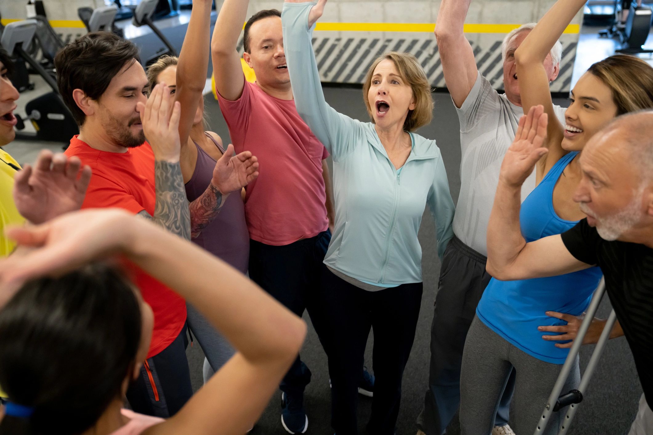Group of diverse people celebrating together in a gym setting.