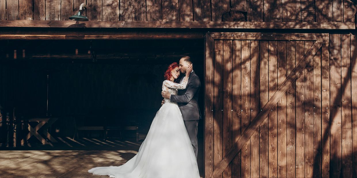 Bride and groom share an intimate moment outside a rustic barn
