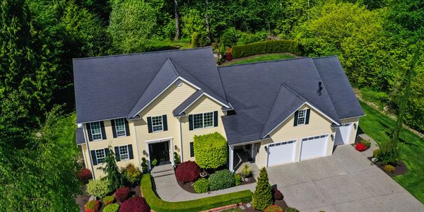 Large suburban home surrounded by greenery.