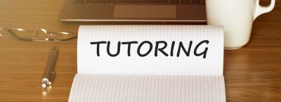 Notepad with the word TUTORING on a desk.
