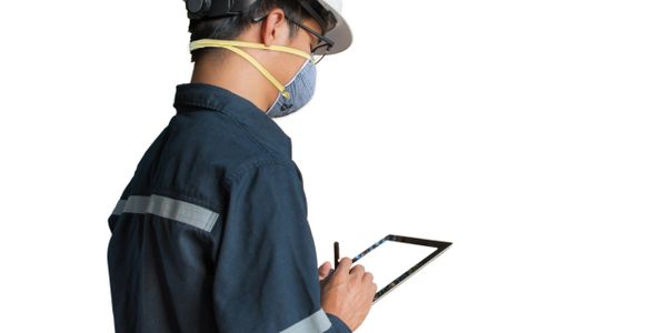 Engineer wearing safety gear using a tablet for work.