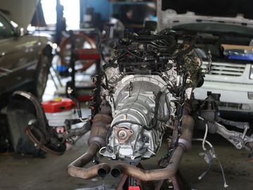 Car engine removed from a vehicle in a workshop.