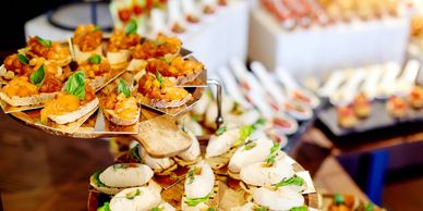 Elegant finger foods arranged on tiered trays for a stylish event.