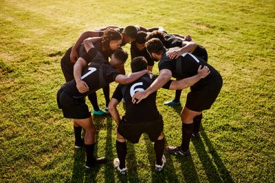 Soccer players huddling on the field before a game.