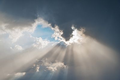 Sunlight beams piercing through dark clouds.