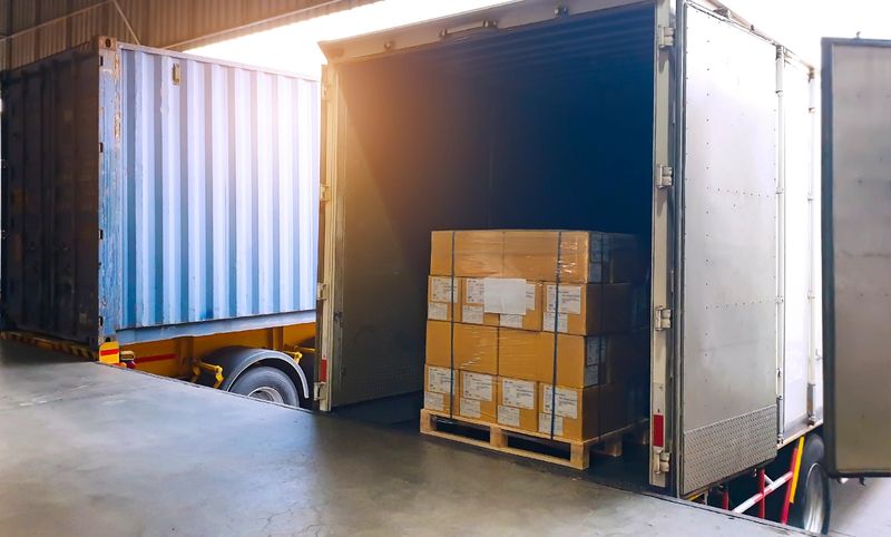 Interior of warehouse dock, Large pallet shipment boxes, Truck docking load cargo at warehouse, Road freight industry logistics shipping and transport