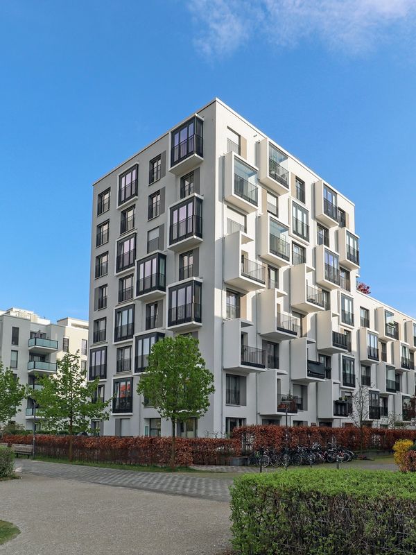 Modern apartment buildings with balconies under a clear blue sky.