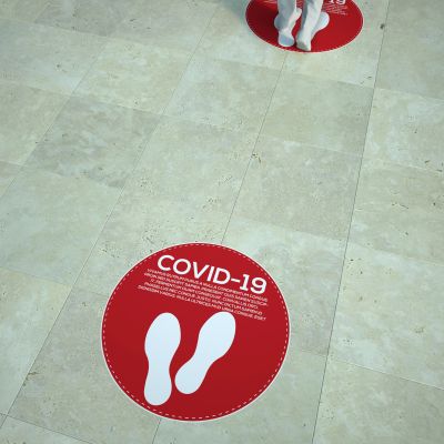 Red COVID-19 social distancing floor markers with footprints.