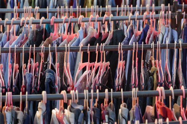 Colorful clothes hanging on racks in a fashion display.

