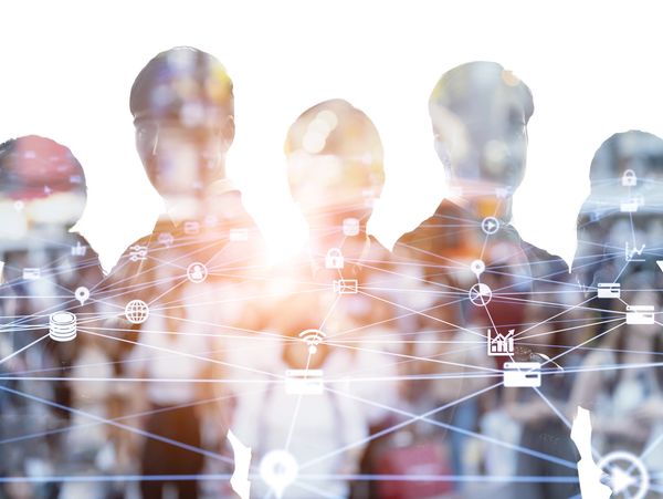 Silhouettes of professionals connected by a digital network of icons symbolizing technology and communication.