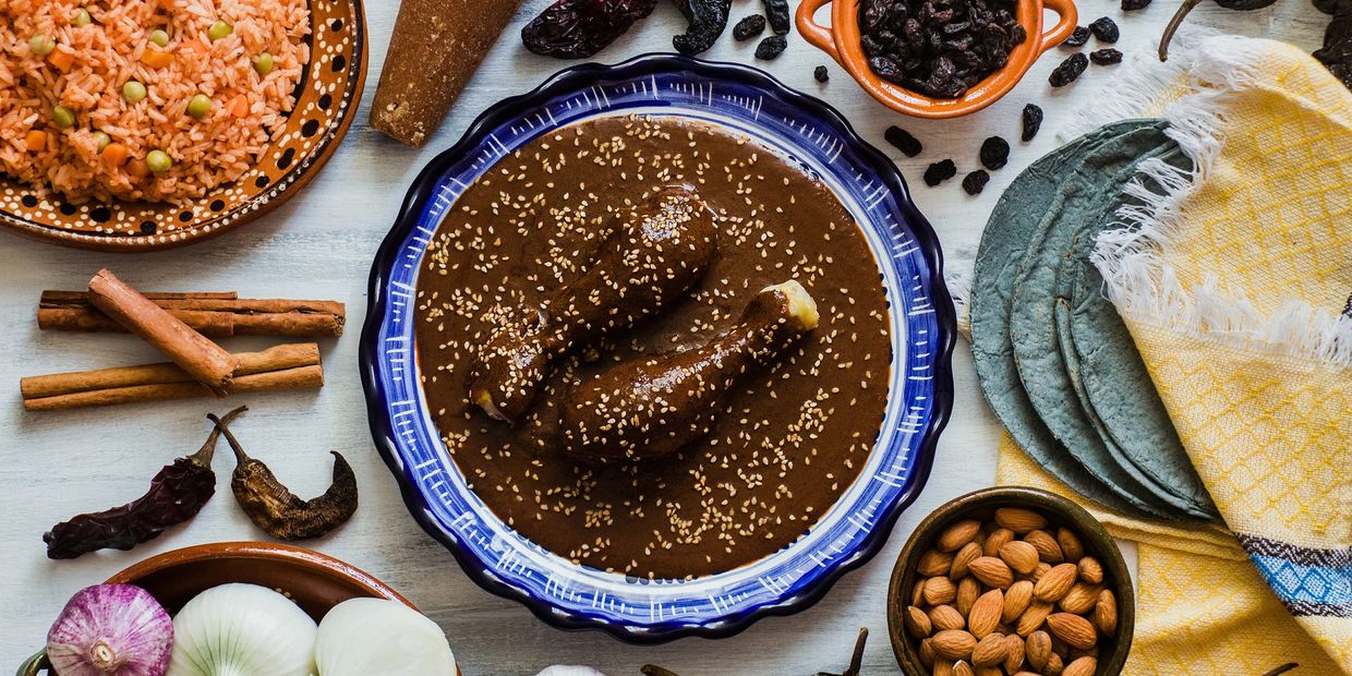 Traditional Mexican mole with chicken, rice, tortillas, and spices.