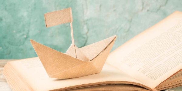 Paper boat on an open book.