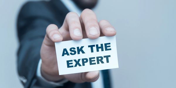Hand holding a card saying "ASK THE EXPERT".