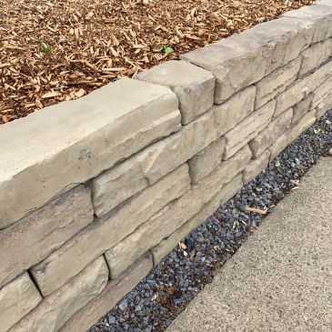 Muro de piedra con camino y mulching.