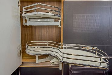 Pull-out kitchen cabinet shelves with metal railings.