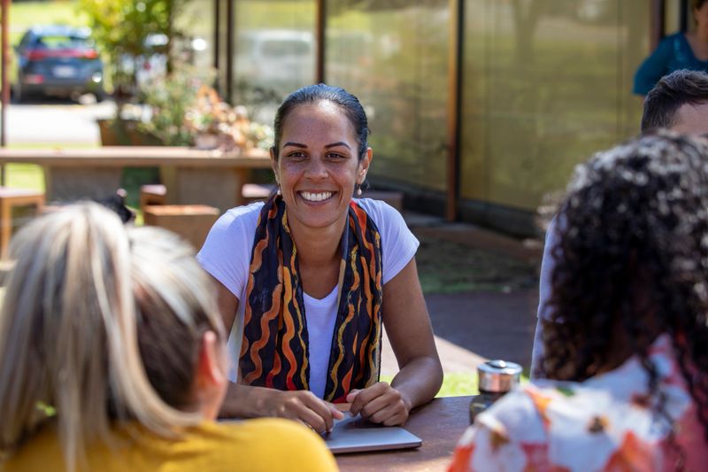 Close-up of young aboriginal students studying together outdoors in the sun in Australia.