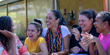 Five women laughing and enjoying each other's company.
