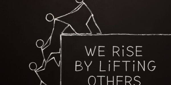 Chalk drawing of helping hands with motivational quote.