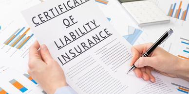 Person holding and signing a Certificate of Liability Insurance.