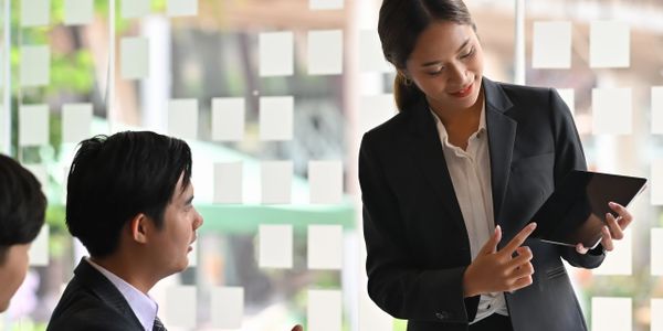 Businesswoman presenting ideas on a tablet during a meeting.