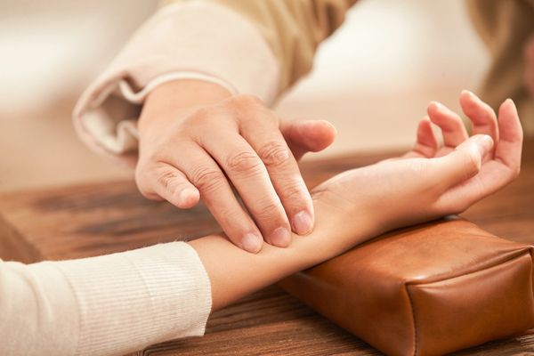 Doctor taking a patient's pulse.