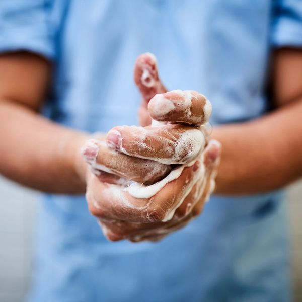 Person washing hands thoroughly with soap and water.