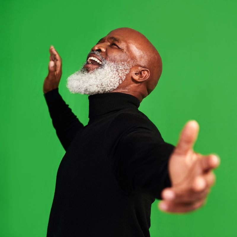 Studio shot of a senior man posing against a green background