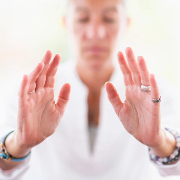 Image of a woman with hands held up projecting distance Reiki energies 