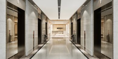 Modern, sleek elevator lobby with reflective surfaces and bright lighting.