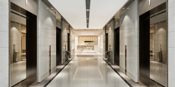 Modern, sleek elevator lobby with reflective surfaces and bright lighting.