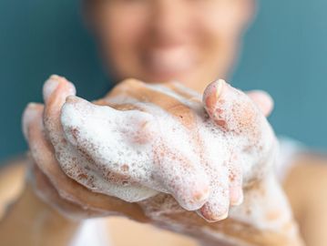 Person washing hands with soap and foam.