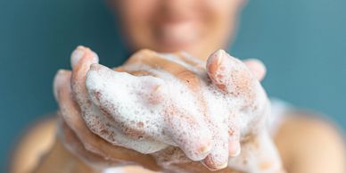Person washing hands with soap foam.