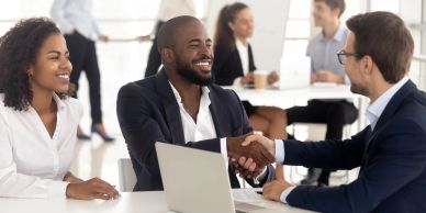 Businesspeople shaking hands in a meeting.